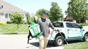 An Upfront Pest technician with a backpack sprayer and wand ready for service in North Kansas City, MO.