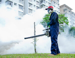 A pest control technician operating a fogging machine outdoors for mosquito or pest control by Sac Pest Pros in Sacramento, CA.