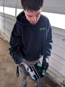 A Safeway Pest Management technician inspecting a pest bait station or trap in Muskego, WI.