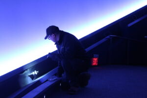A Pestec technician inspecting a dark area for pests or entry points in San Francisco, CA.