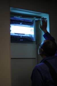 A Pestec technician inspecting an insect light trap for pest monitoring in San Francisco, CA.