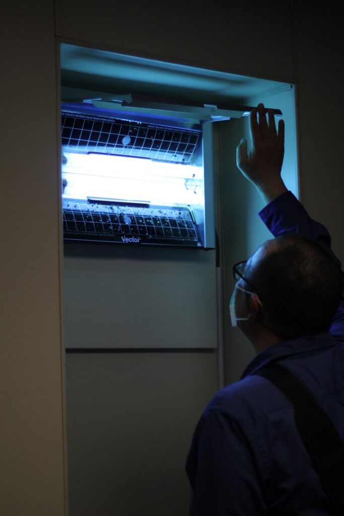 A Pestec technician inspecting an insect light trap for pest monitoring in San Francisco, CA.