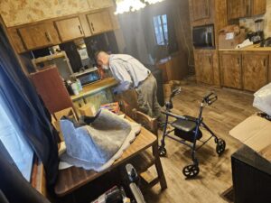 A pest control technician inspecting under a kitchen cabinet for pests at Bye Bye Bugs Pest Control in Indianapolis, IN