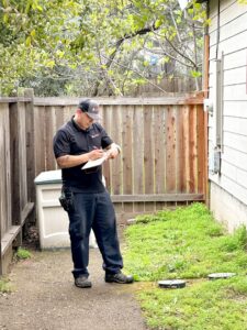 A pest control technician from Aantex Pest Control Norcal inspecting an outdoor area in Sacramento, CA.