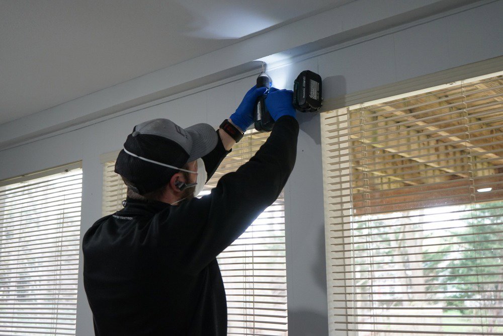 A Fox Pest Control technician installing pest exclusion or sealing entry points in Glen Ellyn, IL