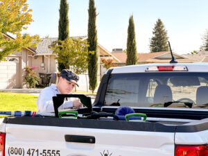 A pest control technician from Aantex Pest Control Norcal preparing equipment in the back of a truck in Sacramento, CA.