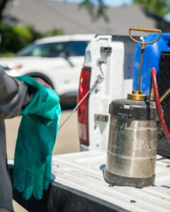 A pest control technician preparing a sprayer on the back of a truck for San Joaquin Pest Control in Fresno, CA.