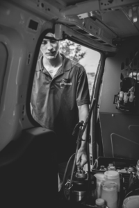 A Chesapeake Pest Control technician preparing a sprayer inside a company van for a job in Chesapeake, VA