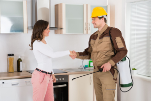A pest control technician from Tri State Pest Management shaking hands with a client in New Castle, DE.