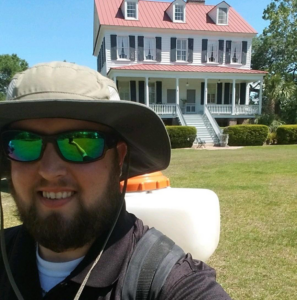A pest control technician with a backpack sprayer at a job site for Magnolia Pest Management in Charleston, SC.