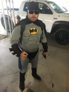 A pest control technician in a Batman costume holding a sprayer, ready for a job at Bakersfield Pest Control in Bakersfield, CA
