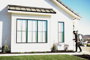 A Pallas Pest Control technician spraying the exterior of a house for pest treatment in Saint George, UT.