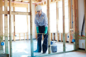 A HomeTeam Pest Defense technician spraying the foundation of a new home under construction in Longwood, FL.