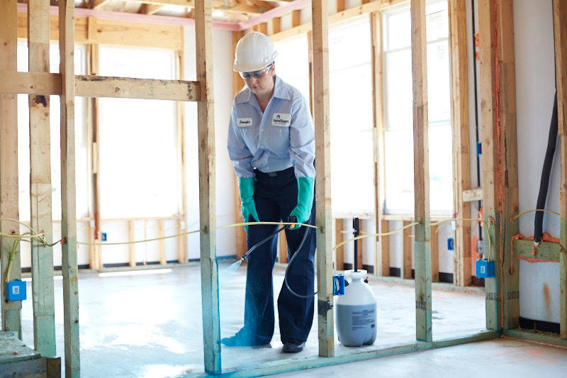 A HomeTeam Pest Defense technician spraying the foundation of a new home under construction in Longwood, FL.