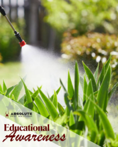 A pest control technician spraying plants in a garden as part of a service by Absolute Pest Solutions in Piedmont, OK.