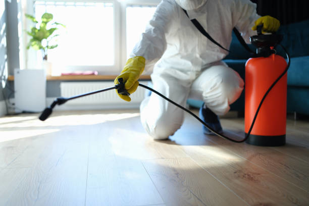A pest control technician in a hazmat suit spraying for pests inside a home by Central Iowa Pest Control Services Inc in West Des Moines, IA
