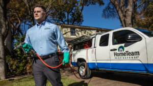 A HomeTeam Pest Defense technician spraying for pests outside a home in Longwood, FL.