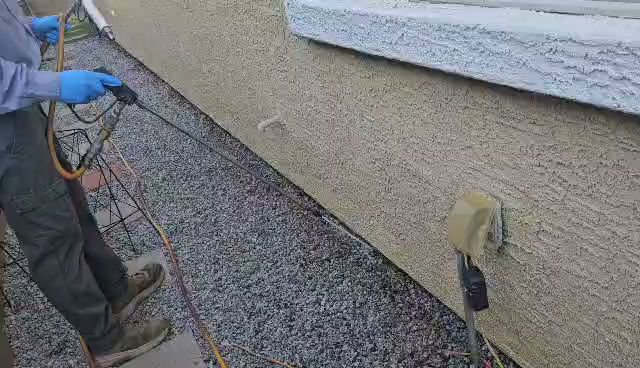 A pest control technician spraying the exterior of a house for pest treatment at Bye Bye Bugs Pest Control in Indianapolis, IN