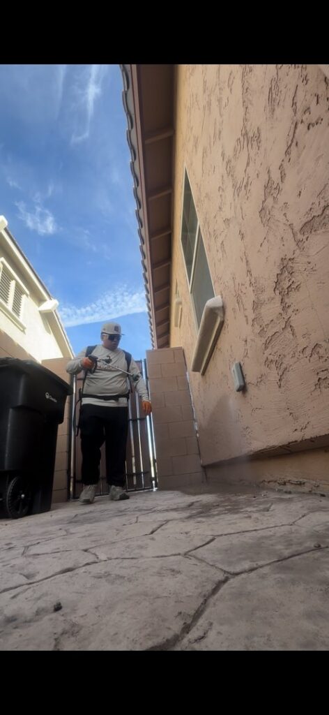 A pest control technician from Sandstorm Pest Control spraying the exterior of a house in Chandler, AZ.