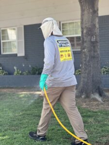 A Mosquito Malone Pest Control technician spraying a lawn for pest control services in Edmond, OK.