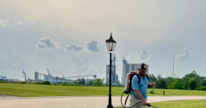 A Mosquito Doctor technician applying pest control treatment with a backpack sprayer in Lake Charles, LA.