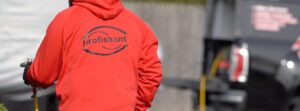 A pest control technician wearing a Profishant hoodie and spraying a treatment for Profishant, inc. in New Bedford, MA.