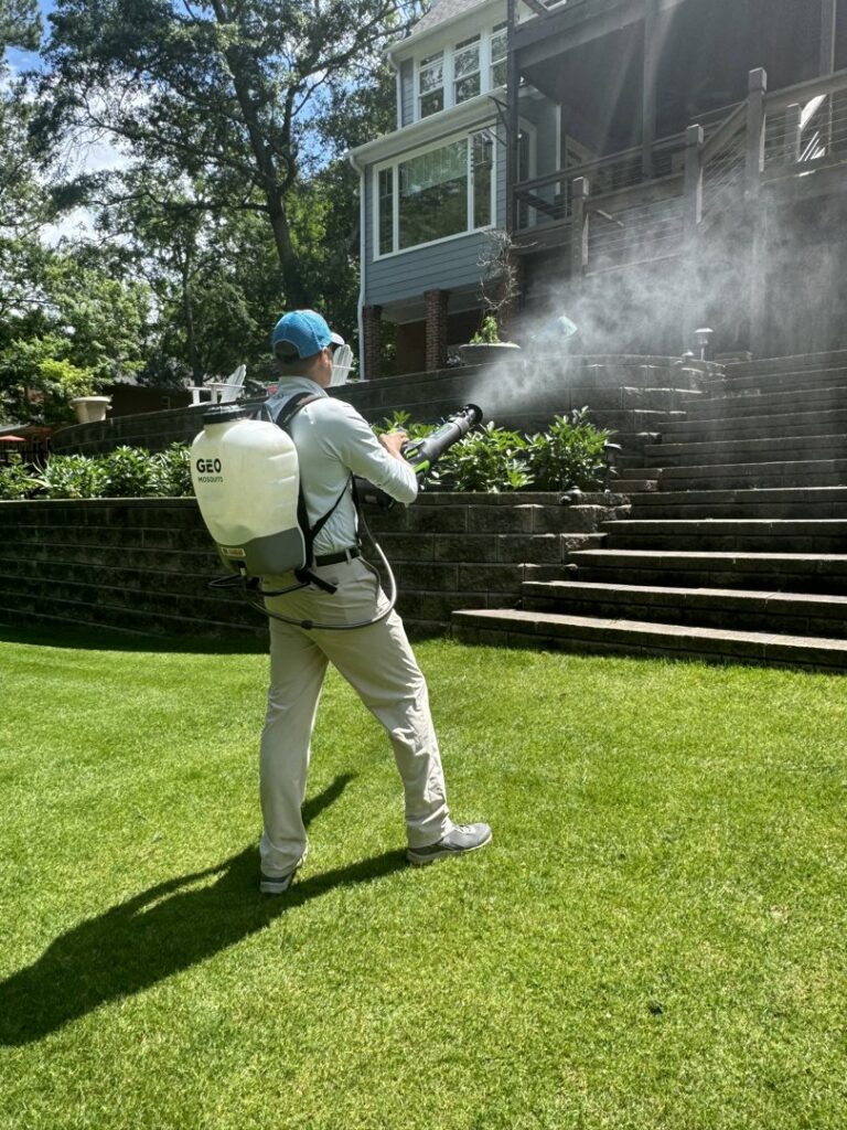 A GeoMosquito LLC pest control technician spraying a residential yard in Roswell, GA