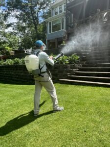 A GeoMosquito pest control technician spraying a residential yard for mosquitoes in Roswell, GA