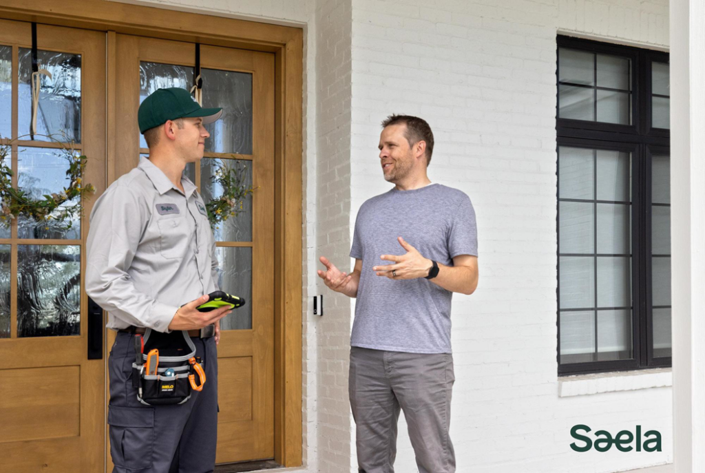 A Saela Pest Control technician talking with a homeowner at the front door in Hubbard, OR.