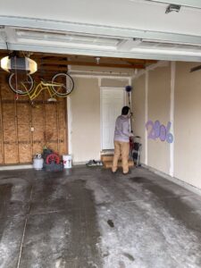 A pest control technician treating a garage interior with a long pole for Defend Pest Solutions in Sioux Falls, SD.