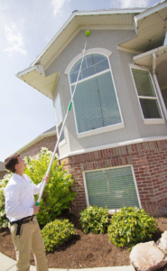 A pest control technician from EDGE - The Service Company treating the eaves of a house in Bridgeview, IL.