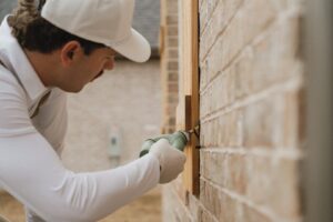 A Breezy Pest Control technician applying treatment to the exterior of a home in Little Rock, AR.