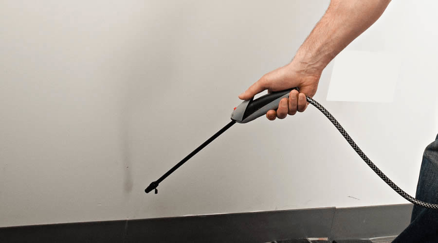 A pest control technician treating a wall or crevice with a sprayer for pest control by Best Pest Control Services in Corpus Christi, TX.