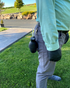 A Nature Shield Pest & Lawn technician with a bulb duster tool attached to their belt in Meridian, ID.