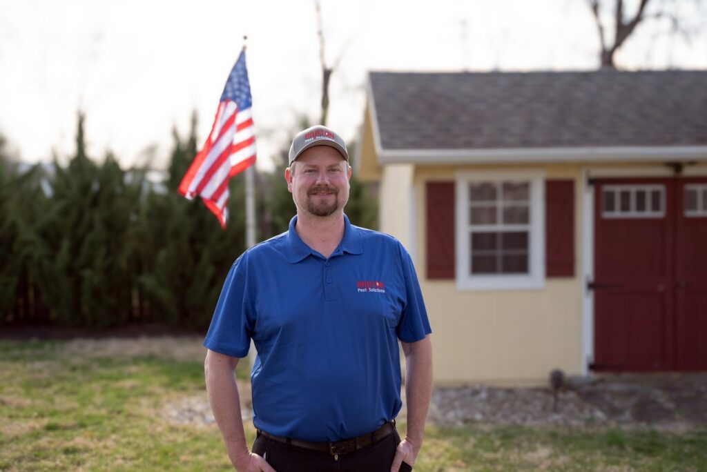 A Barton Pest Solutions technician holding a pest control sprayer, prepared to perform services in York, PA.