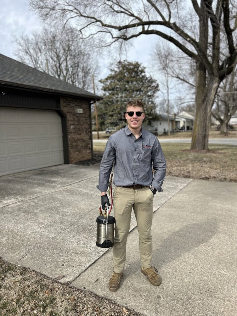 A Reliable Pest Management technician in uniform holding a sprayer, ready to perform pest control services in Springfield, MO.