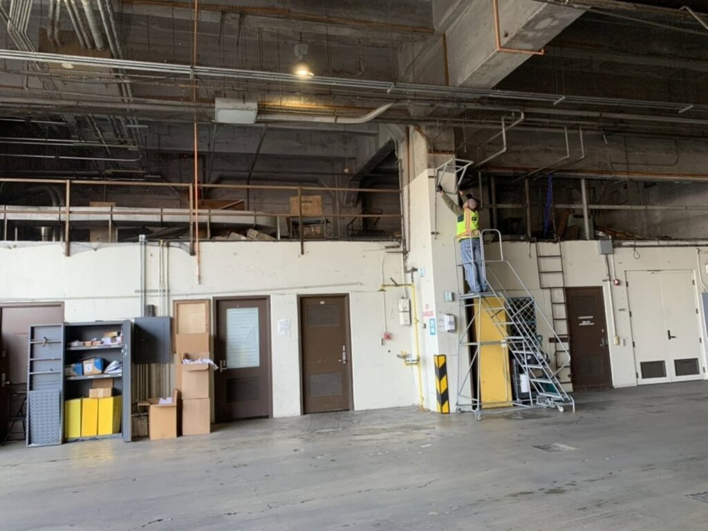 A Pestec technician working on overhead pest control measures inside a building in San Francisco, CA.