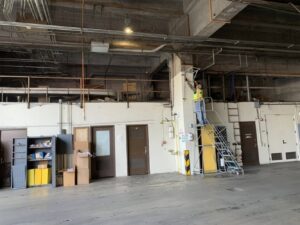 A Pestec technician working on overhead pest control measures inside a building in San Francisco, CA.