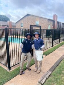 Two BBK Pest Control technicians in uniform with equipment, ready for a job near a pool in Dallas, TX.