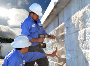 Two Pestec technicians installing a pest exclusion barrier on a building exterior in San Francisco, CA.