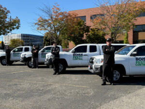 Pest Control Service Boise technicians standing with their branded trucks in Boise, ID, ready for wildlife and pest control jobs.