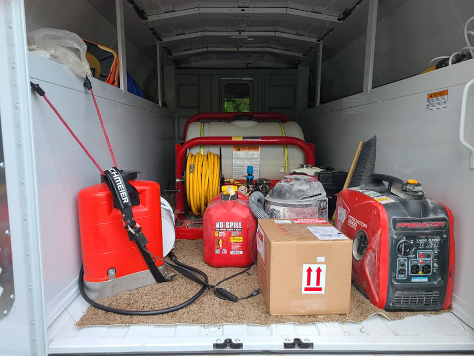 Various pest control tools and equipment, including sprayers and a generator, inside a Monocacy Pest Control vehicle in New Market, MD.