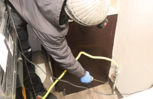 A pest control technician applying treatment with a nozzle in a home for Buggin Out Pest Control in Elizabeth, NJ