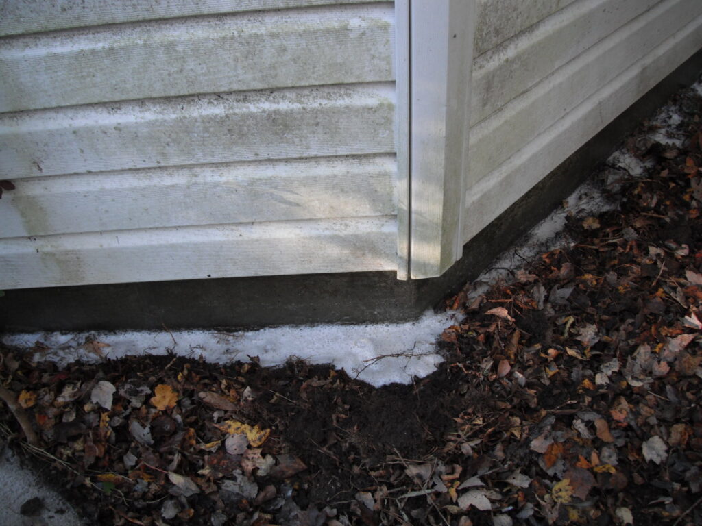 White pesticide dust applied along a house foundation for pest control by General Pest Solutions in Summerville, SC.