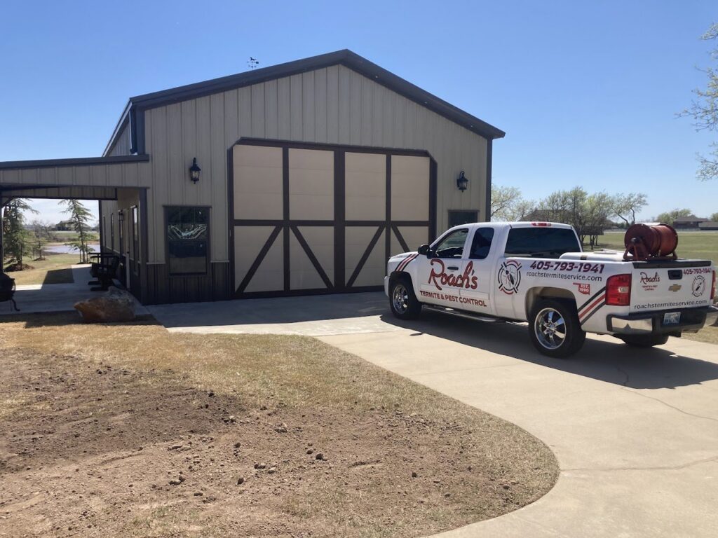 A Roach's Termite Service Inc. truck with pest control equipment parked at a commercial property in Oklahoma City, OK