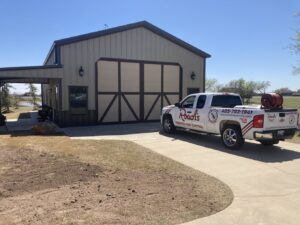 A Roach's Termite Service Inc. truck with pest control equipment parked at a commercial property in Oklahoma City, OK