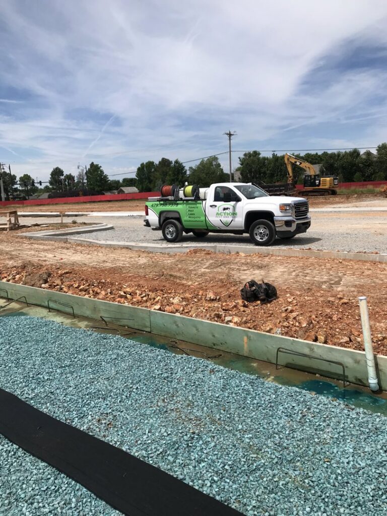 An Action Pest And Turf service truck at a construction site for pest control in Springdale, AR.