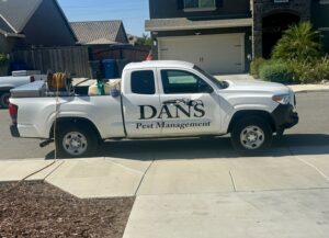 A white pest control truck with equipment and Dan's Pest Management logo in Bakersfield, CA