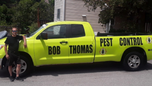 A Bob Thomas Pest Control truck parked in a rural setting under a dark sky in Latrobe, PA.