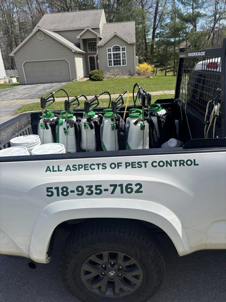 A Sheridan Pest Control truck loaded with multiple backpack sprayers for pest services in Albany, NY.